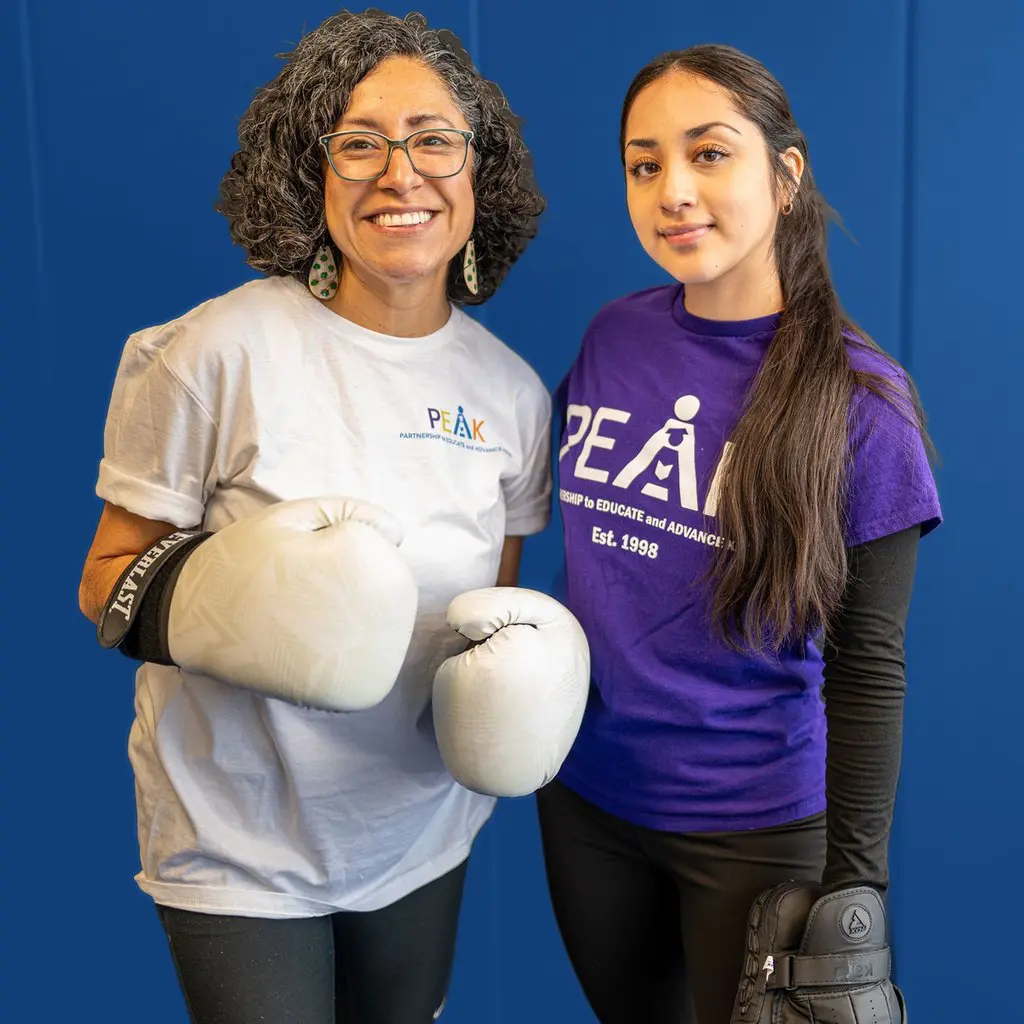 A mentor and a PEAK scholar in boxing gloves at a PEAK event