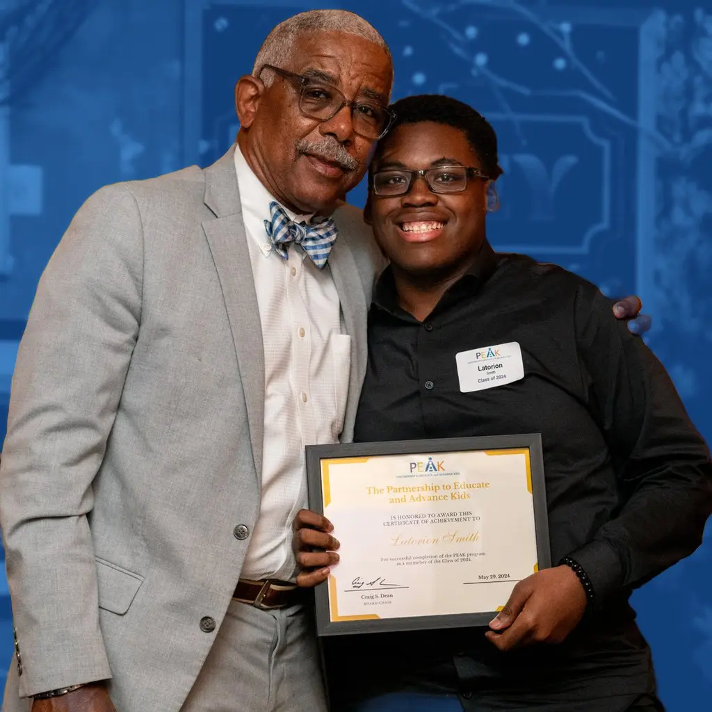 A mentor and a PEAK scholar holding an award certificate