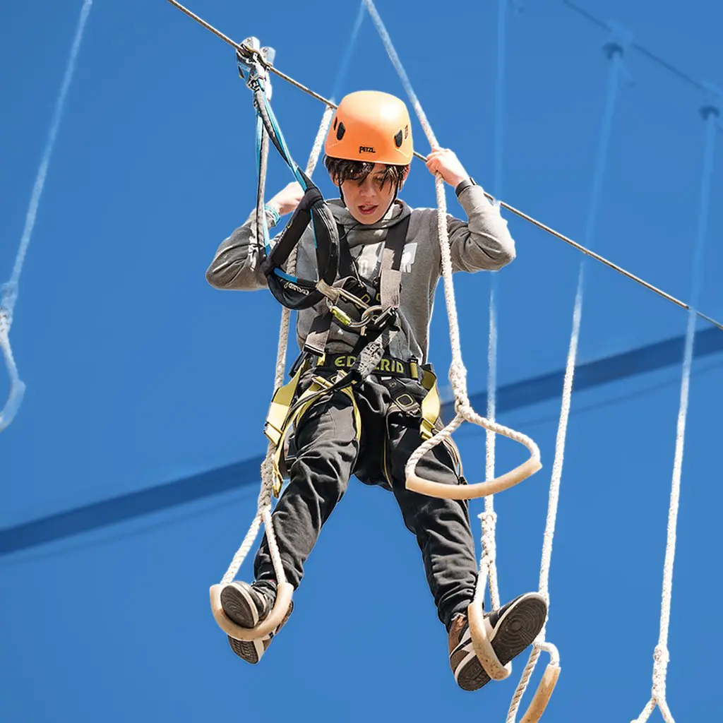 A PEAK scholar crossing a ropes course